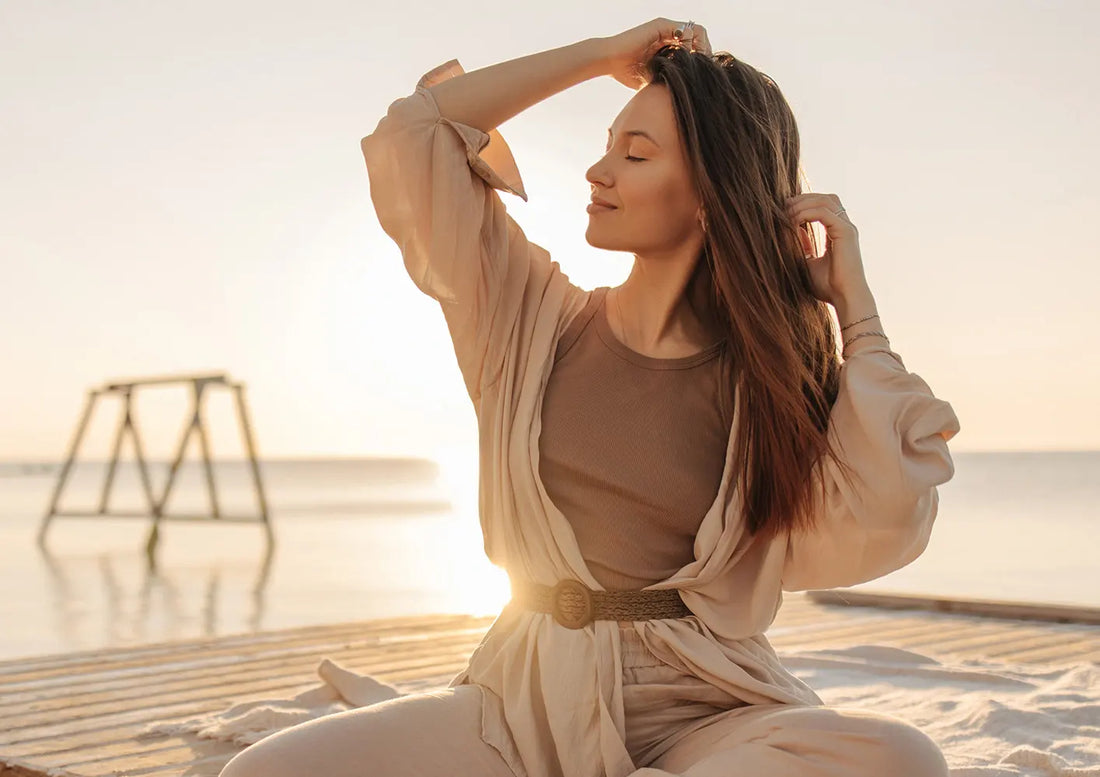 młoda kobieta na plaży przy zachodzącym słońcu